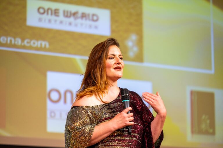 Melanie Dorn spricht mit Mikrofon auf einer Bühne